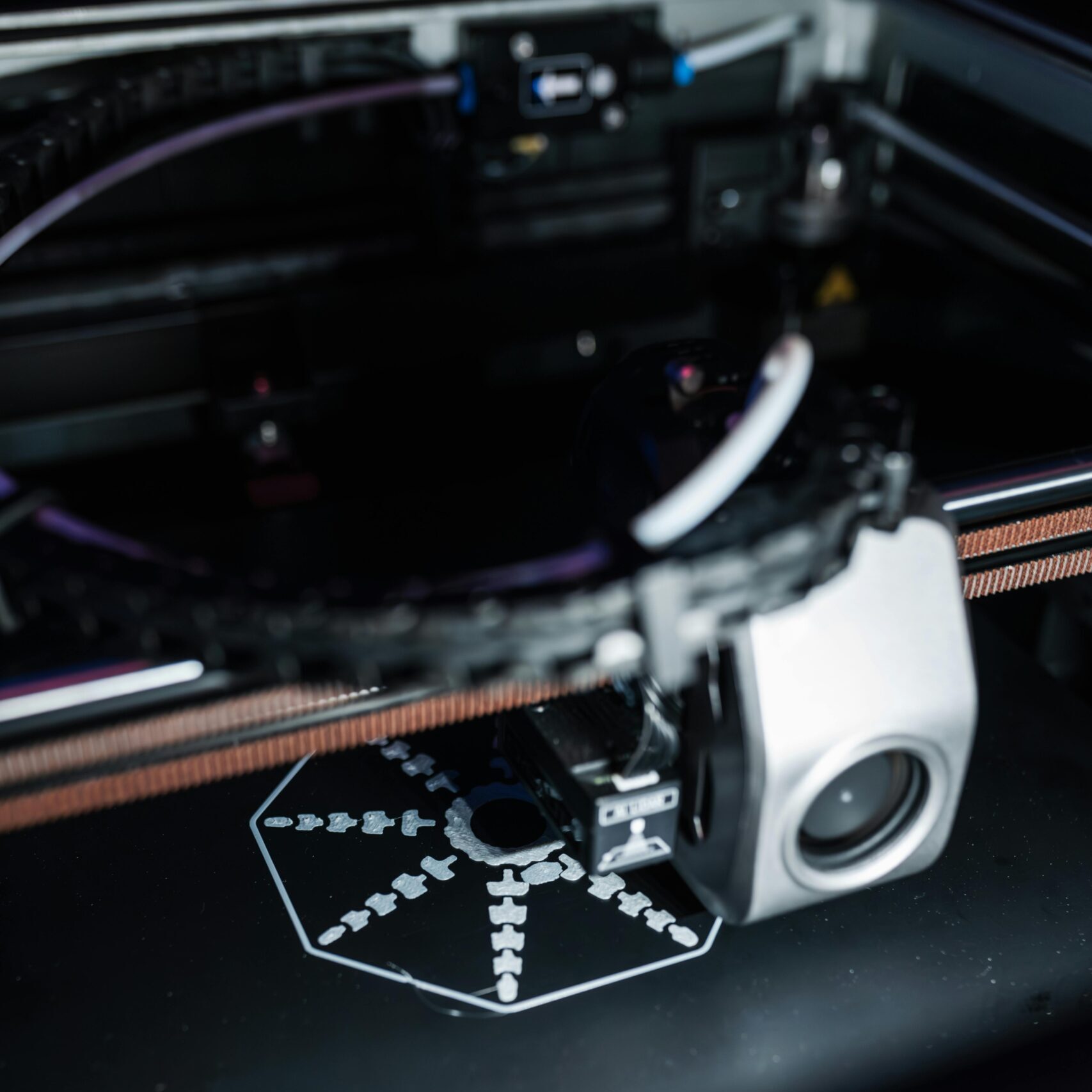 Detailed view of a 3D printer creating a precise object, showcasing advanced technology.